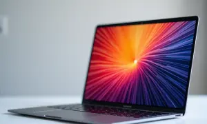 Elegancki laptop z kolorowym, abstrakcyjnym tłem na ekranie. Dowiedz się, jak obrócić ekran, aby dopasować go do swoich potrzeb.