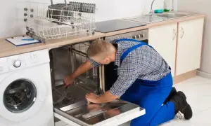 Serwisant naprawia zmywarkę Bosch, która wyświetla błąd E15. Widać też pralkę i kosze na naczynia.