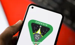 Dłoń trzyma smartfon z logo Android 15 w kosmicznym motywie.