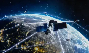 Satelity Starlink tworzą sieć połączeń wokół Ziemi, oświetlonej nocnymi światłami miast.