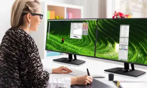 Kobieta pracuje przy dwóch monitorach z wąską ramką (bezel), edytując zdjęcie tarasów ryżowych.
