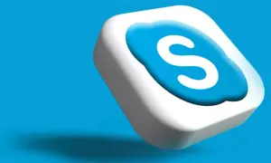 Trójwymiarowe logo Skype, biała chmurka z niebieską literą "S", unosi się na błękitnym tle.