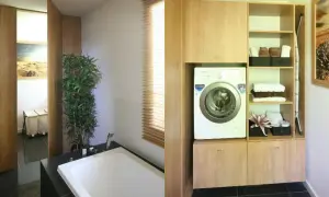 Nowoczesna łazienka z wanną i pralką. Wysokość pralki idealnie dopasowana do zabudowy z półkami na ręczniki.