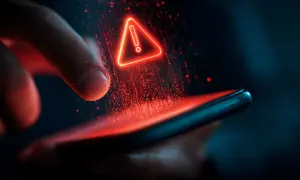Czerwony trójkąt z wykrzyknikiem nad smartfonem, symbolizujący problem z aktualizacją telefonu.
