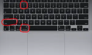Klawiatura MacBooka z zaznaczonymi klawiszami: Shift, Command i cyfrą 3.