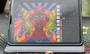 Kolorowy portret kobiety z motylimi skrzydłami, tworzony w aplikacji Adobe Fresco na tablecie. Widoczne narzędzia symetrii.