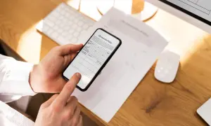 Ręce trzymają telefon, który działa jak skaner w telefonie, skanując dokument "Life Insurance Policy".