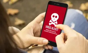 Osoba wykonuje skanowanie telefonu, gdy na ekranie pojawia się czerwony komunikat "VIRUS ALERT!".