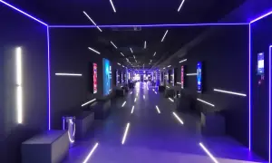 Nowoczesny korytarz multikina z neonowym oświetleniem, idealny do projekcji filmowych dzięki zaawansowanemu projektorowi laserowemu.