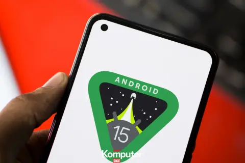 Dłoń trzyma smartfon z logo Android 15 w kosmicznym motywie.