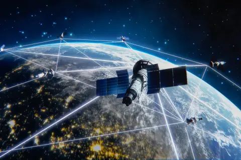 Satelity Starlink tworzą sieć połączeń wokół Ziemi, oświetlonej nocnymi światłami miast.