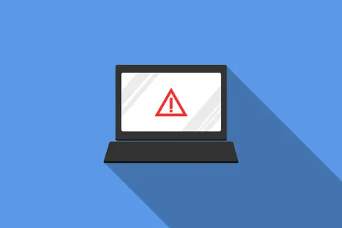Laptop z czerwonym znakiem ostrzegawczym na ekranie. Symbolizuje zagrożenie w cyberbezpieczeństwie.