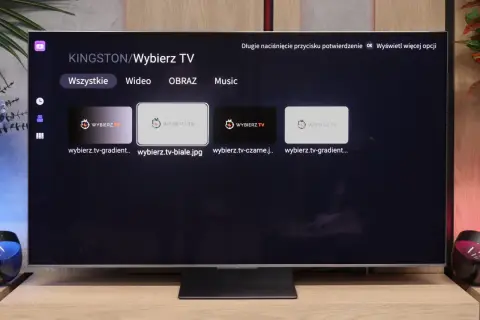 Menu aplikacji smart iptv na telewizorze, z opcjami "Wszystkie", "Wideo", "Obraz", "Music" i miniaturkami plików.