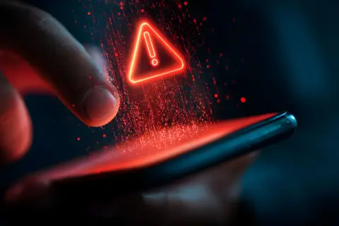 Czerwony trójkąt z wykrzyknikiem nad smartfonem, symbolizujący problem z aktualizacją telefonu.
