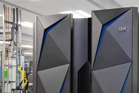 Nowoczesny mainframe IBM z niebieskimi akcentami, otoczony infrastrukturą techniczną.