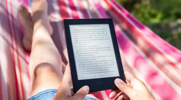 Osoba relaksuje się w hamaku, czytając e-booka. Idealny sposób na relaks, gdy szukasz najlepszego czytnik ebook ranking.