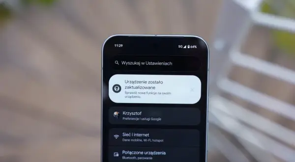 Ekran telefonu z powiadomieniem o aktualizacji systemu. Widoczna jest godzina 11:29, ikona 5G, poziom baterii 64% i menu ustawień, w tym opcje "Sieć i internet" oraz "Połączone urządzenia", typowe dla systemu Android 16.
