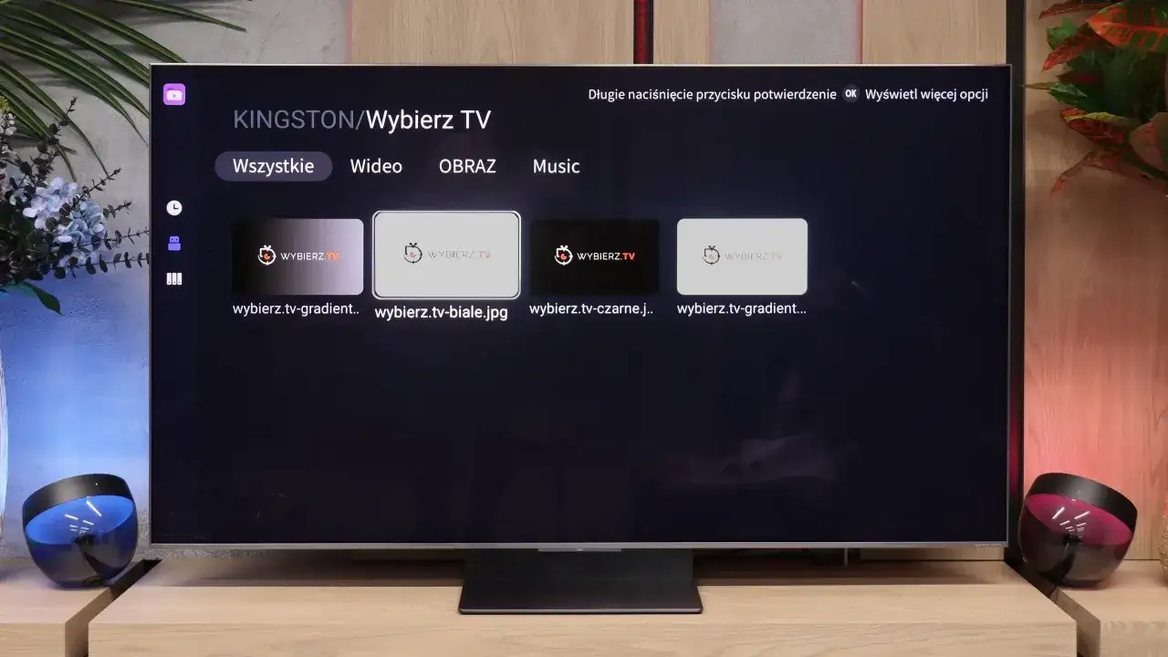 Menu aplikacji smart iptv na telewizorze, z opcjami "Wszystkie", "Wideo", "Obraz", "Music" i miniaturkami plików.