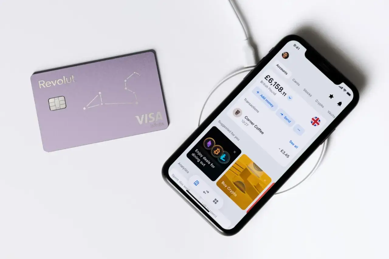Fioletowa karta Revolut i smartfon z aplikacją bankową. Revolut to nowoczesny sposób na zarządzanie finansami, płatności i inwestycje.