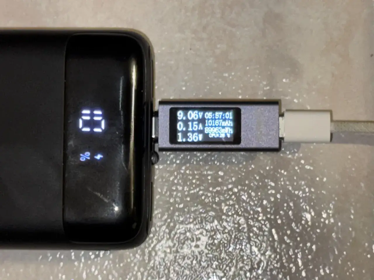 Powerbank z wyświetlaczem 23% ładuje się, a miernik pokazuje 10167 mah.