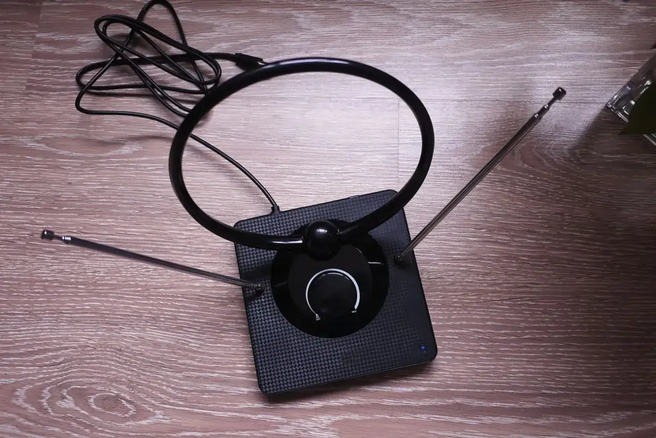 Czarna antena pokojowa z okrągłą pętlą i teleskopowymi wysięgnikami, idealna jako najlepsza antena do telewizji naziemnej.
