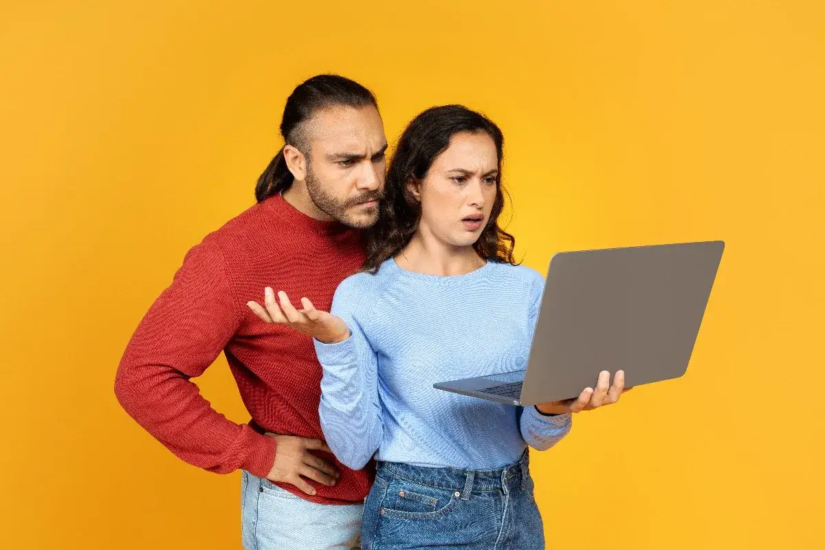 Para zdezorientowana patrzy na laptopa, jakby problem z msvcp140.dll uniemożliwił im pracę.