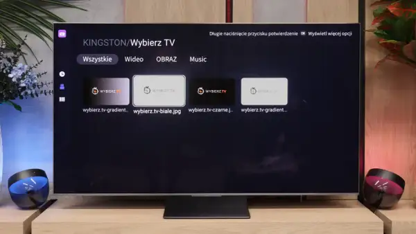 Menu aplikacji smart iptv na telewizorze, z opcjami "Wszystkie", "Wideo", "Obraz", "Music" i miniaturkami plików.